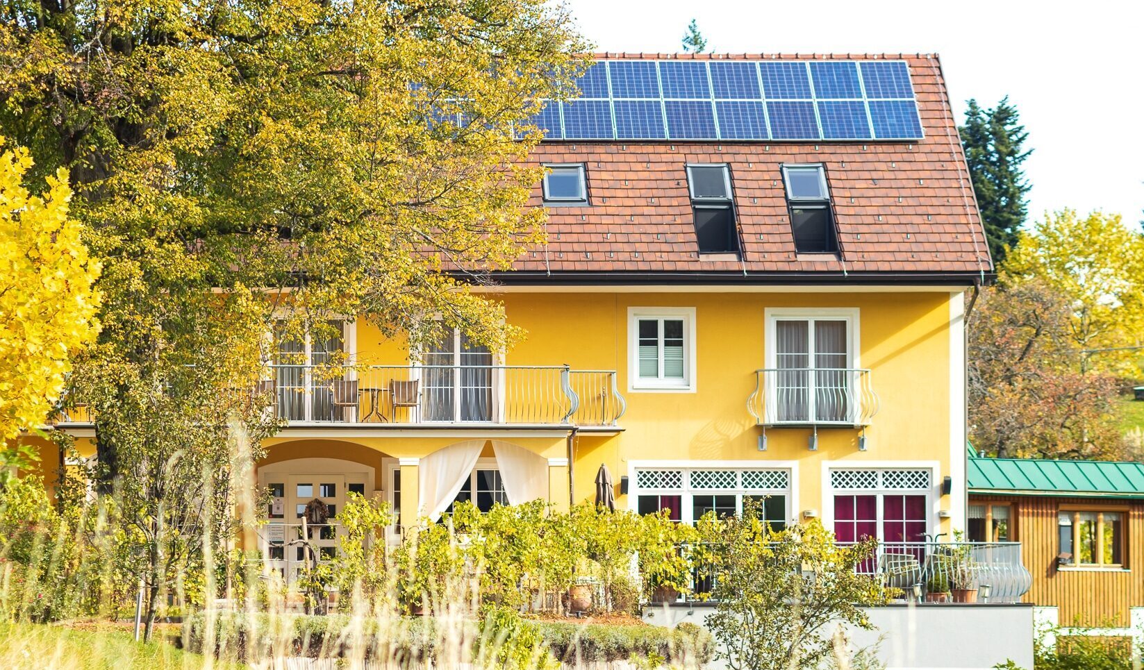 Die gelbe Fassade des Hotels in warmer Herbststimmung