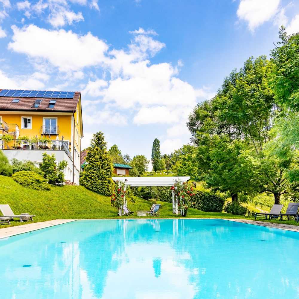 Außenansicht des Hotel Gut Moser mit Pool im Vordergrund